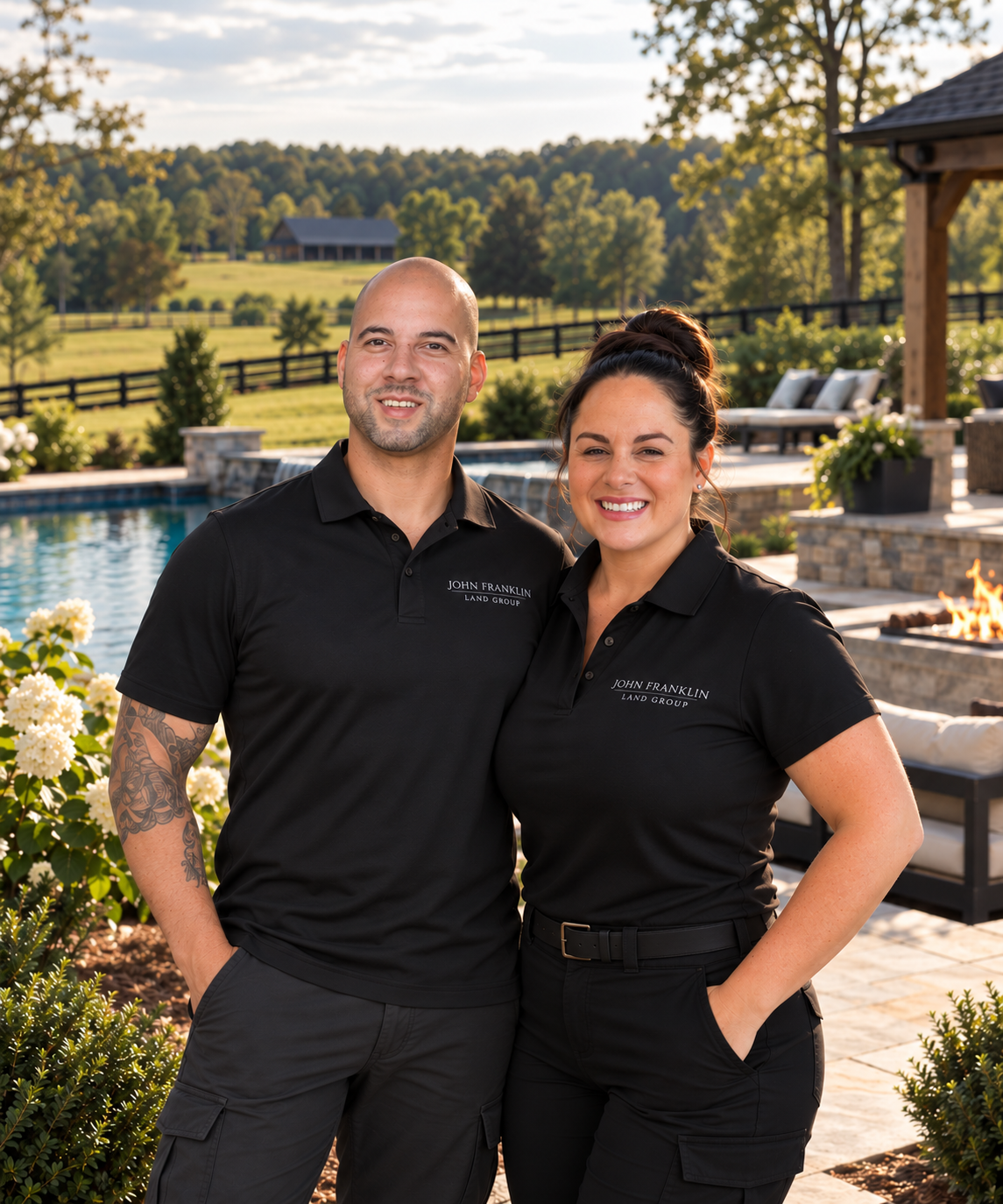 Ryan Hare and Jena Kranz of John Franklin Land Group in branded black polos on a finished North Georgia estate with pool, fire pit and pasture fencing