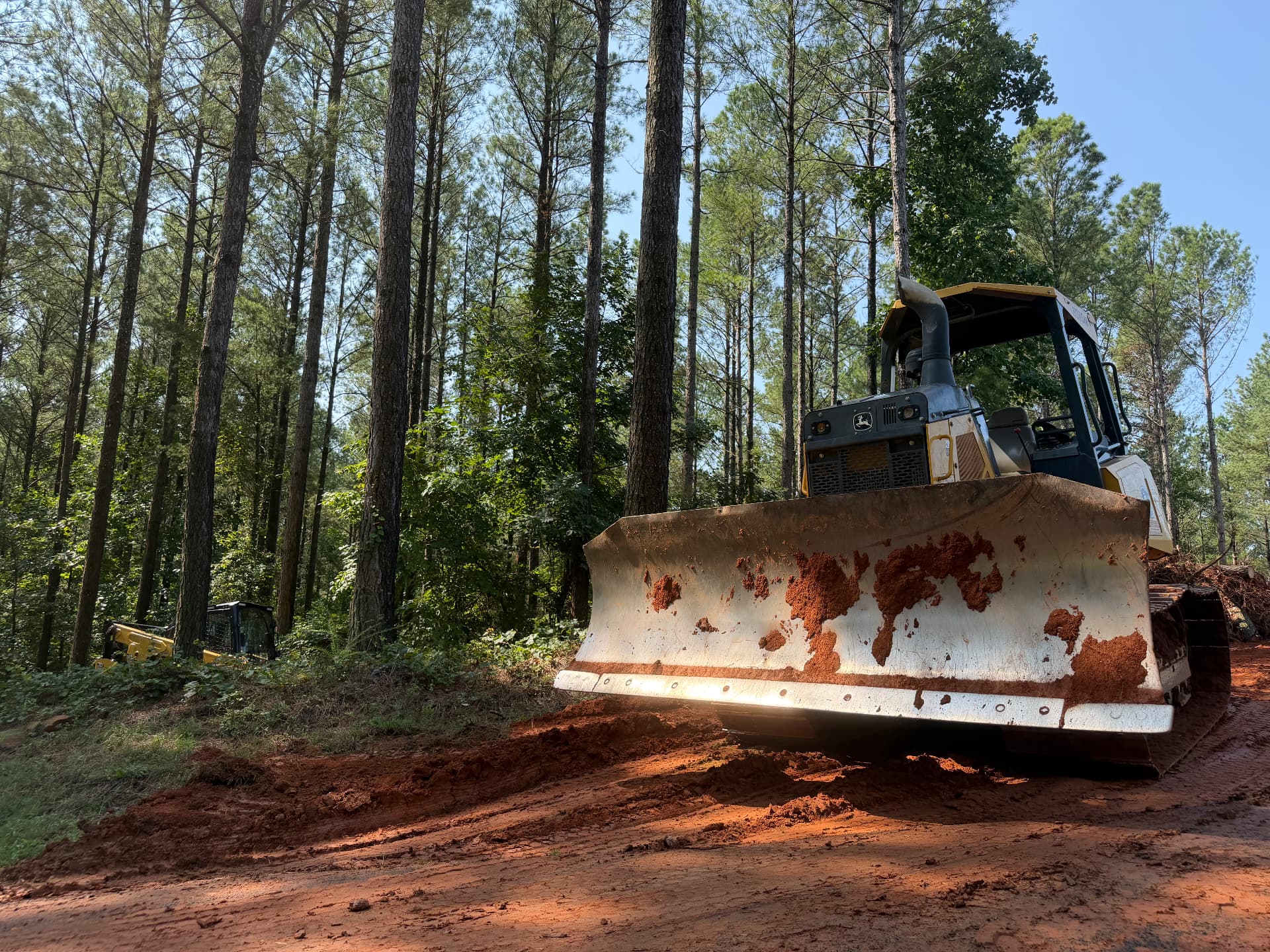 Dozer clearing a new access road through a pine stand on a North Georgia land clearing project